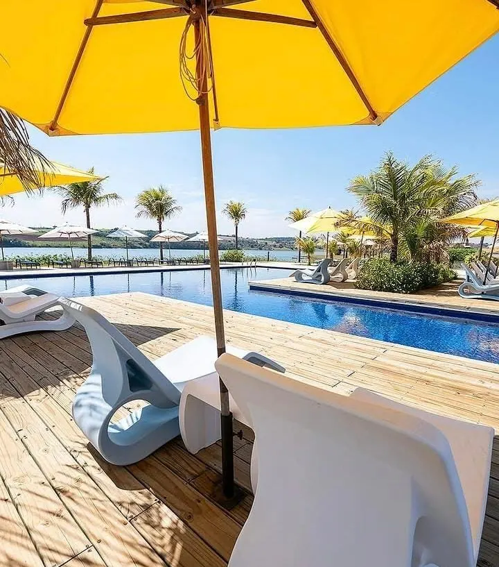 Deck da piscina do clube com guarda-sol amarelo