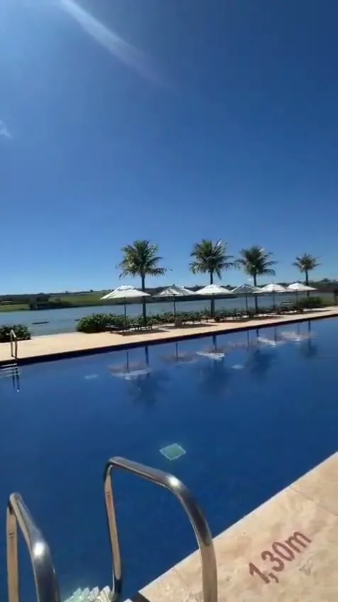 Piscina do clube com coqueiros, às margens da represa
